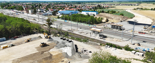 Výstavba v UČS 2 ŽST Zohor, v popredí nadjazd SO 02-33-02 ŽST Zohor, nový cestný nadjazd na obchvate obce Zohor v nžkm 12,880 vrátane výstavby obchvatu, vľavo hore práce na nástupištiach a v koľajisku